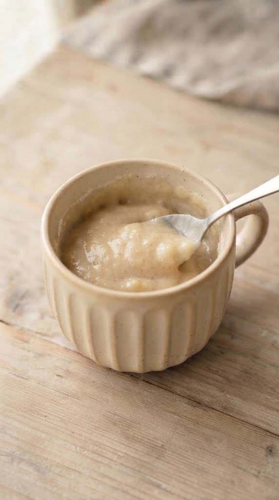 Thick banana mug cake batter after flour, sugar, baking powder, cinnamon, and salt have been gently stirred in