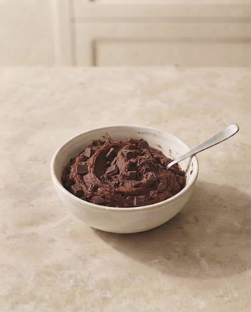 Rich cocoa cookie dough with a generous amount of dark chocolate pieces folded throughout